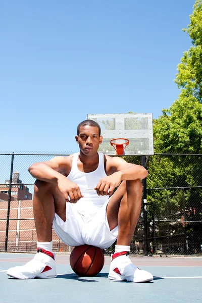 Basketbol oyuncusu topun üzerinde oturan — Stok fotoğraf