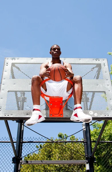Jogador de basquete sentado em aro — Fotografia de Stock