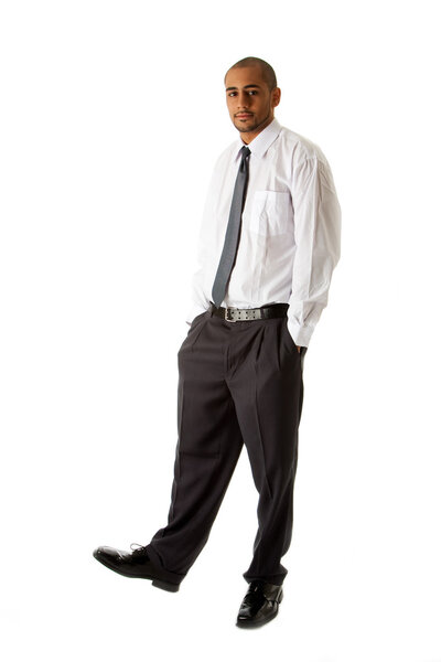 Handsome African Hispanic business man in white shirt, gray pants and tie, standing with hands in pocket, isolated