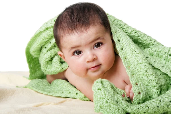 Bebê feliz bonito entre cobertores verdes — Fotografia de Stock