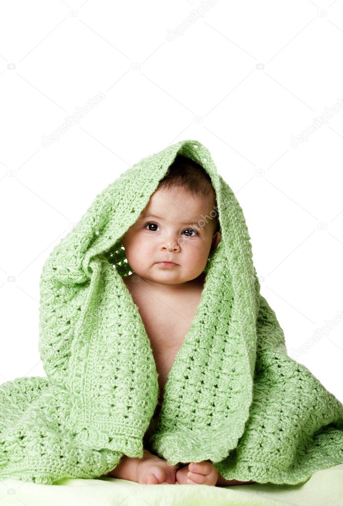 Cute baby sitting between green blanket.