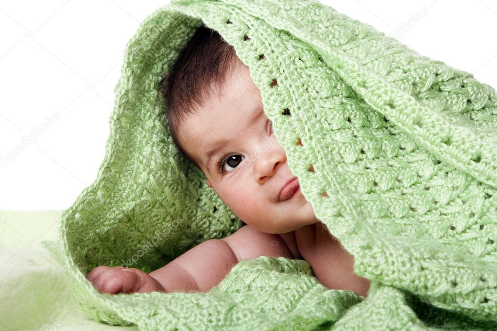 Cute happy baby between green blankets