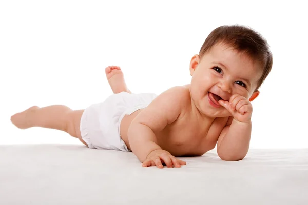 Happy baby laying with thumb in mouth. — Stock Photo, Image
