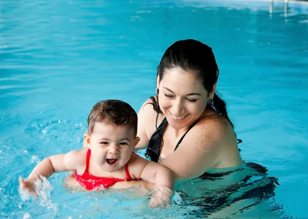 Madre enseñando natación bebé Imagen de stock