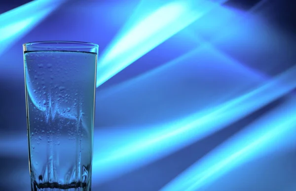 Un vaso de agua sobre un hermoso fondo — Foto de Stock