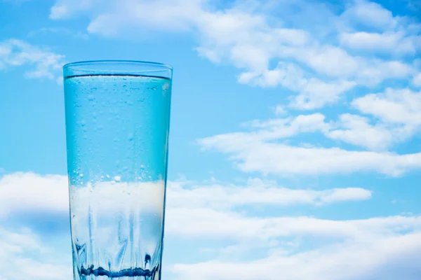 Un vaso de agua sobre un hermoso fondo — Foto de Stock