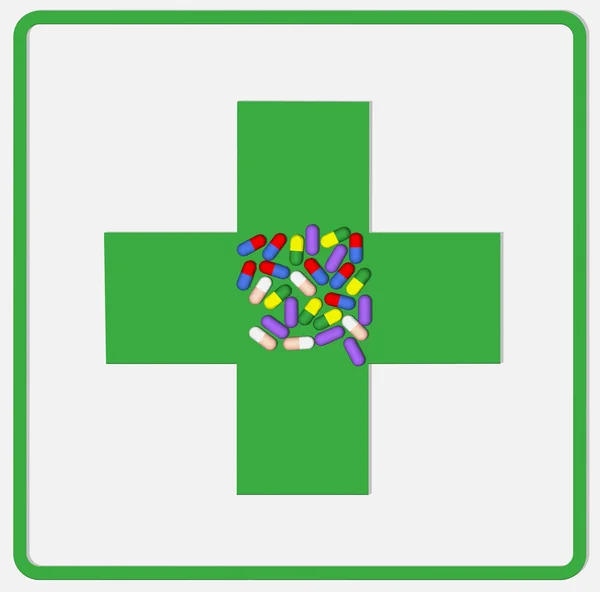 Cápsulas medicinales en una cruz verde . — Foto de Stock