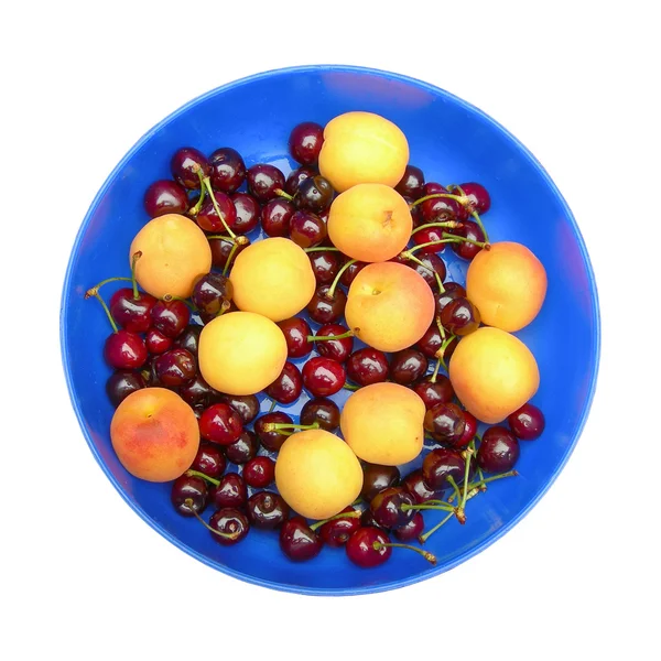 Apricots and cherries on the blue dish. — Stock Photo, Image