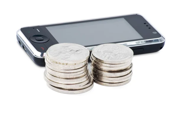 Сотовый телефон и стопки монет — стоковое фото