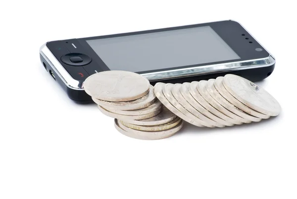 Telefon komórkowy i stosy monet — Zdjęcie stockowe