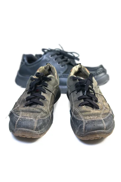 Alte Sportschuhe gegen neue Schuhe. — Stockfoto
