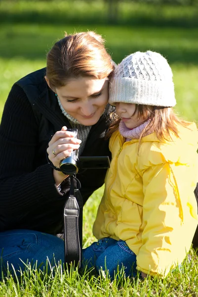Motehr and daughter view a video recording on the camcorder — Stock Photo, Image