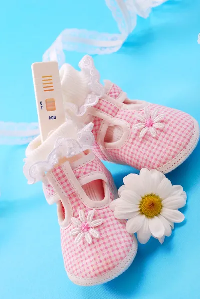 Těhotenský test a dětské boty — Stock fotografie