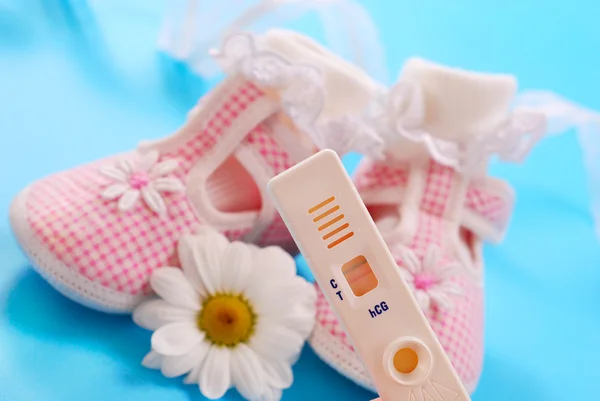 Teste de gravidez e sapatos de bebê — Fotografia de Stock