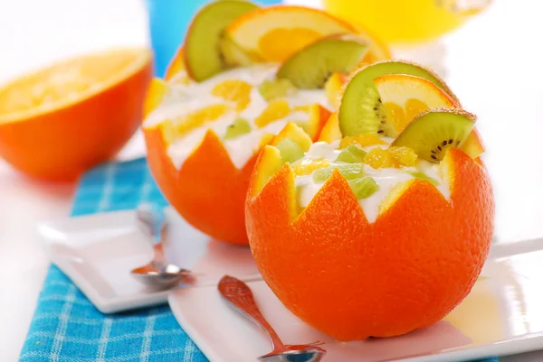 Йогурт и фруктовый десерт в апельсине — стоковое фото
