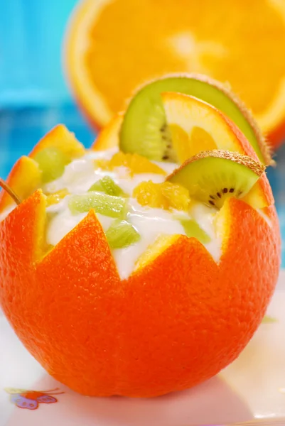 Йогурт и фруктовый десерт в апельсине — стоковое фото