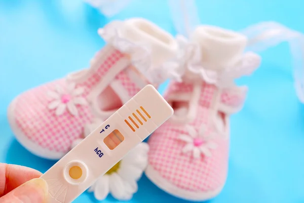 Baby shoes for girl and pregnancy test — Stock Photo, Image