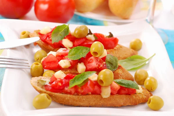 Rostade crostini med mozzarella och tomat — Stockfoto
