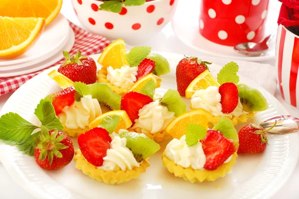 Mini tartlets with whipped cream and fruits — Stock Photo, Image