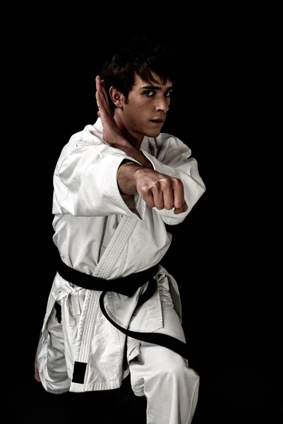 Kontrast karate mladý bojovník na černém pozadí — Stock fotografie