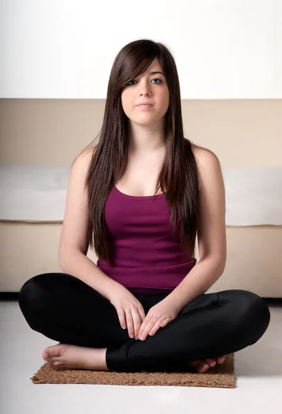 Mujer joven practicando yoga en casa — Foto de Stock