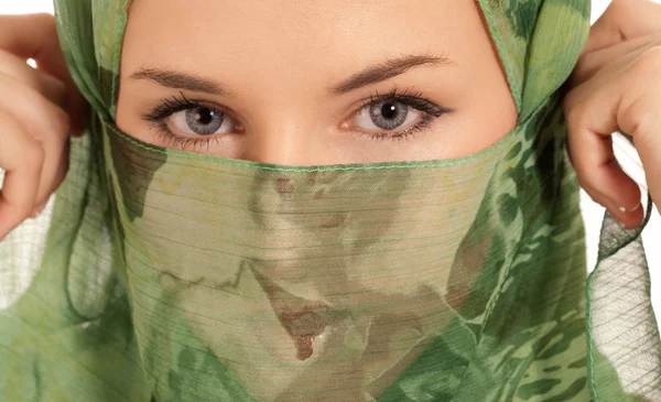 genç Arap kadın gözleri izole beyaz arka plan üzerinde gösterilen peçe ile