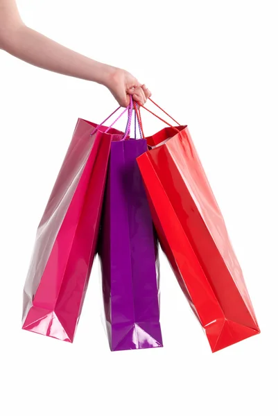 Mão feminina segurando sacos de compras isolados no fundo branco — Fotografia de Stock
