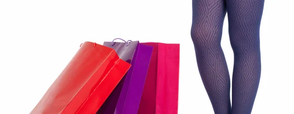 Shopping tassen en vrouw benen dragen slipje geïsoleerd op witte achtergrond. — Stockfoto