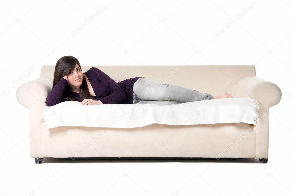 Young beautiful woman lying on sofa isolated on white background