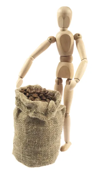 Wooden figure and a bag of coffee beans — Stock Photo, Image