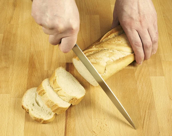 Mulher cortando pão por faca — Fotografia de Stock