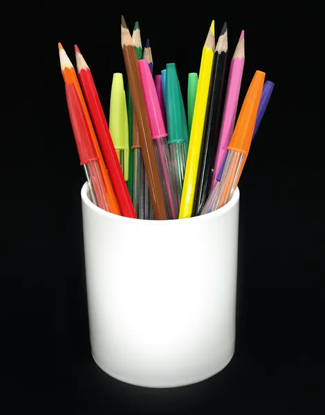 Colored pencils and pens in a jar agains — Stock Photo, Image