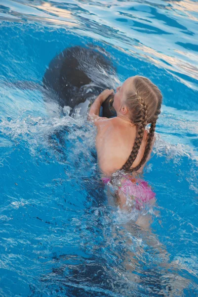 The girl floats with a dolphin — Stock Photo, Image