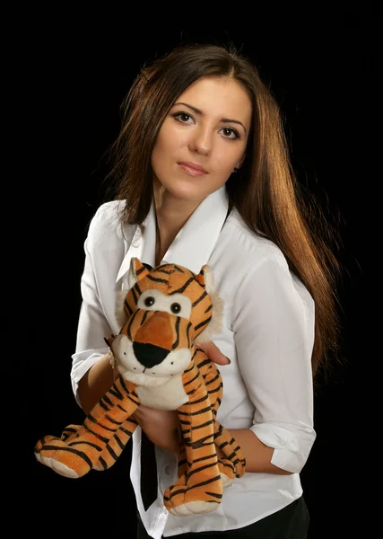 Het meisje met een stuk speelgoed tijger — Stockfoto