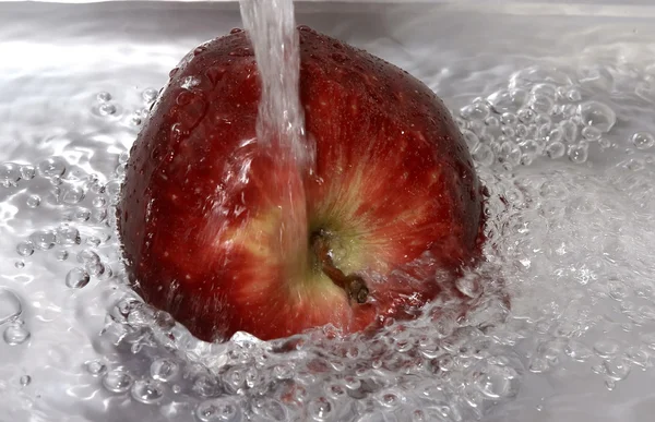 Rode appel onder een waterstraal — Stockfoto