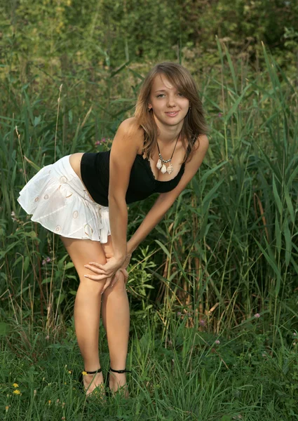 A bela menina em uma grama verde — Fotografia de Stock