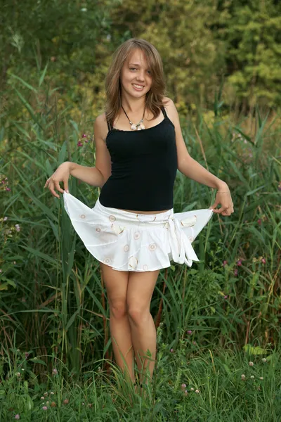 Het mooie meisje op een groen gras — Stockfoto