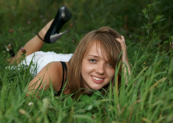 Het mooie meisje op een groen gras — Stockfoto