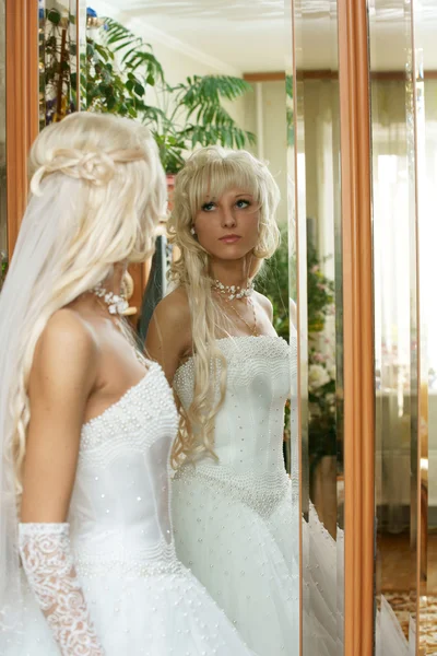 Красивая невеста смотрит в зеркало . — стоковое фото