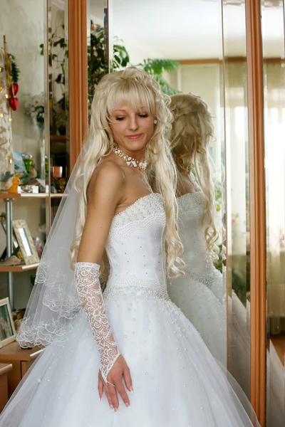 Красивая невеста стоит перед зеркалом — стоковое фото
