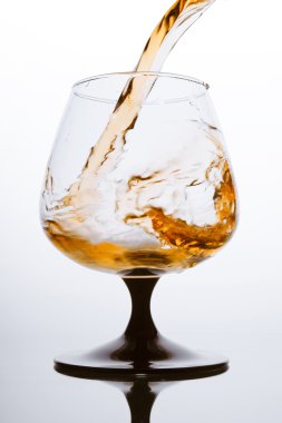 Brandy pouring. Fiery splash in glass. clipart