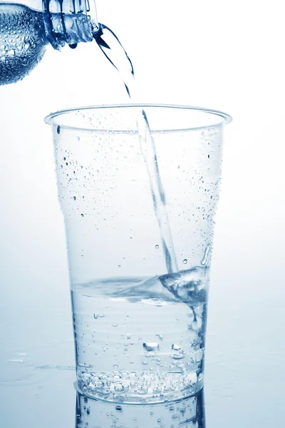 Agua vertiendo en taza de plástico — Foto de Stock