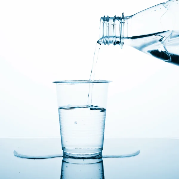 Vatten hälla på plast glas — Stockfoto