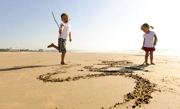 Kids writing in sand — Stockfoto