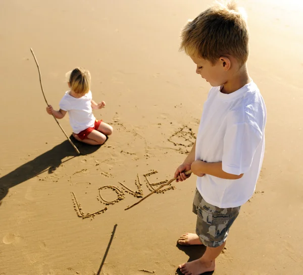 Дети пишут на песке — стоковое фото