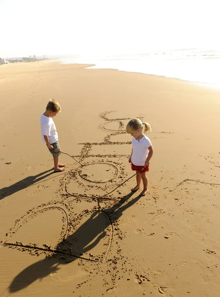 Kids writing in sand — Stockfoto