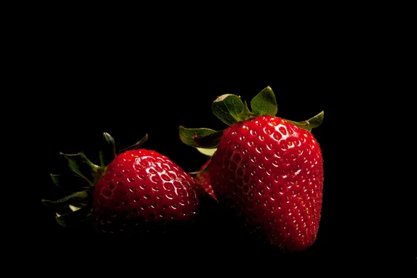 Erdbeeren auf schwarz — Stockfoto