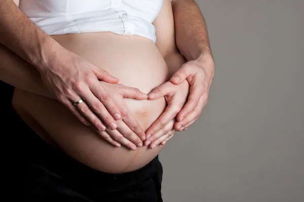 Fortgeschrittener Schwangerschaftsbauch mit Händen — Stockfoto