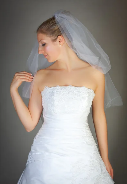 Bruid poseren in bruiloft jurk en sluier — Stockfoto