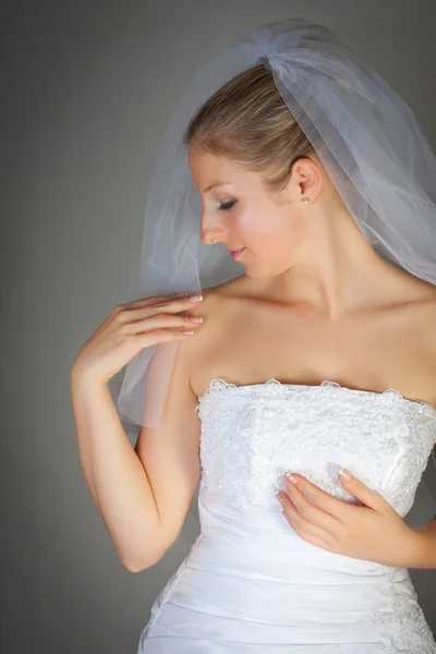 Brud poserar i bröllopsklänning och slöja — Stockfoto